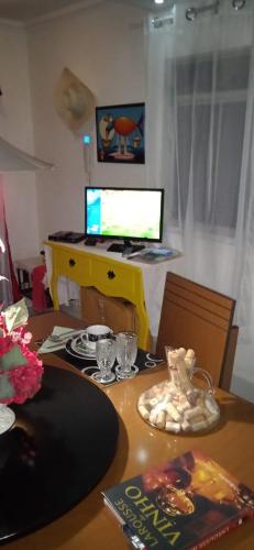 a desk with a computer on top of a table at MINHA CASA,SUA CASA in São Bento do Sapucaí