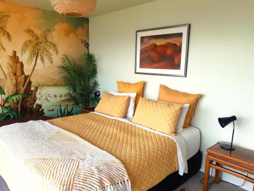 a bedroom with a bed and a painting on the wall at Once Upon a Tide in Auckland
