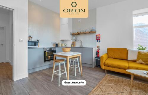 a kitchen and a living room with a couch and a table at The Kepties 4 - Luxurious Serviced Apartment by ORION SHORT STAYS in Arbroath