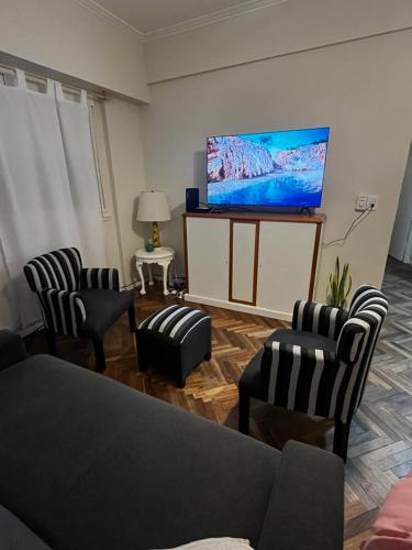 a living room with chairs and a flat screen tv at Departamento Plaza Colón Yeyita in Mar del Plata