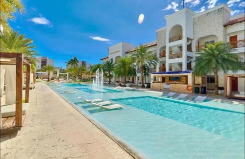 a swimming pool with a fountain in front of a building at Sunset View, Tanama Lodge Cap Cana, Punta Cana in Punta Cana