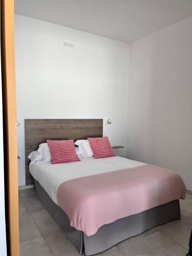 a bedroom with a bed with red pillows at Sombra de Guanapay in Teguise