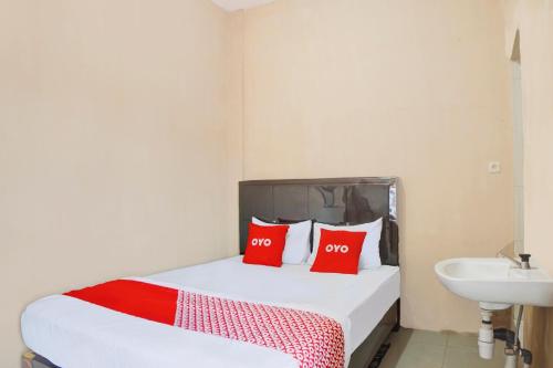Ένα ή περισσότερα κρεβάτια σε δωμάτιο στο Hotel O Penginapan Syariah Faster Inn