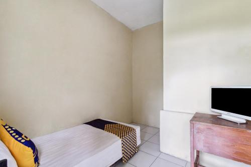 a small room with a tv and a bed at Hotel O Al Mahira Syariah in Majalengka