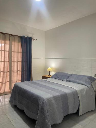 a bedroom with a large bed with blue pillows at Casa ciudad de San Luis in San Luis