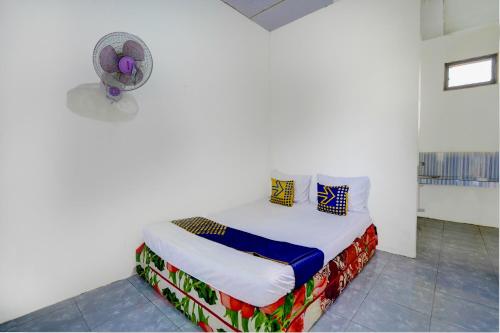 バニュワンギにあるSPOT ON 92855 Griya Sandi Syariah Rogojampiの白い部屋(ファン付きベッド1台付)
