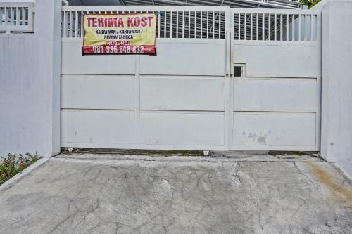 a white garage door with a sign on it at Hotel O Niza Guesthouse Syariah in Banyuwangi