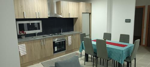 a kitchen with a table with chairs and a stove at Casa do campo in São João