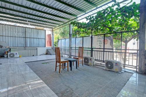 a patio with two chairs and a table and speakers at OYO Life 92877 Hotel Rainbow 7296 in Semarang