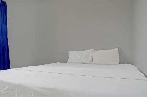 a white bed with white sheets and pillows at Hotel O Home Stay Syariah Aom Kusman in Sukabumi