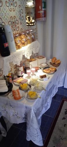 a table with plates of food on it at MINHA CASA,SUA CASA in São Bento do Sapucaí