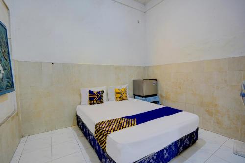 a bedroom with a bed and a tv in it at Hotel O Homestay Kedamean in Gresik