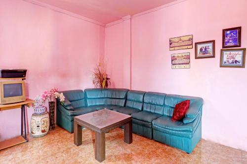 un salon avec un canapé bleu et une table dans l'établissement Hotel O Toyo Homestay Syariah, à Nagoya