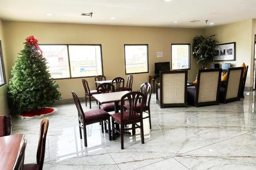 a dining room with a christmas tree and tables and chairs at OYO Hotel Rome West GA in Rome