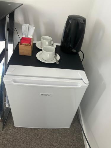a white refrigerator with two cups on top of it at Guest Suite - Walk to Havelock North Village in Havelock North
