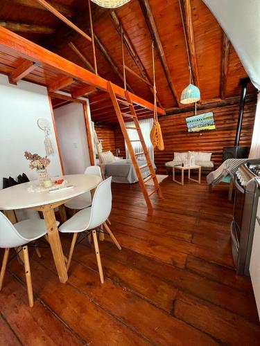 a dining room with a table and chairs and a stove at Cabaña Puesta del sol in Chascomús