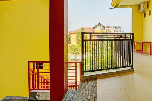 un balcon avec un portail et un mur jaune dans l'établissement OYO Life 93036 Eddy Homestay Syariah, à Lamongan