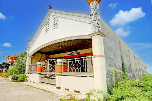 a building with a gate in front of it at Hotel O Karman's Sari Homestay Syariah in Gresik