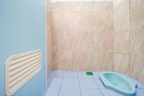 a bathroom with a toilet in the corner of a shower at Hotel O Karman's Sari Homestay Syariah in Gresik