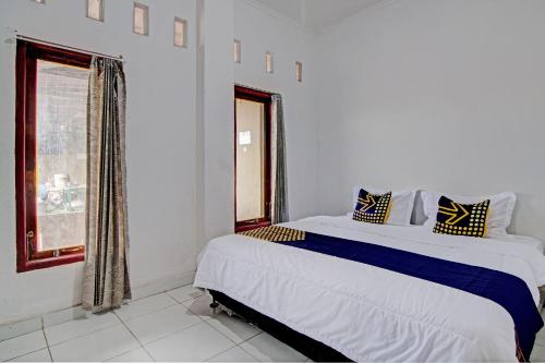 a bedroom with a large bed and a window at Hotel O Meranti HomestayNearJembatan Siak in Pekanbaru