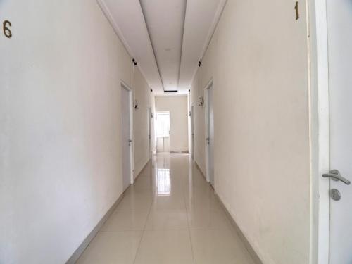 an empty hallway with white walls and a long corridor at OYO Life 92707 D-akomiba Residence in Jambi