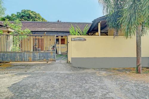 a house with a gate and a palm tree at OYO Life 92954 Shanti Kost in Singaraja