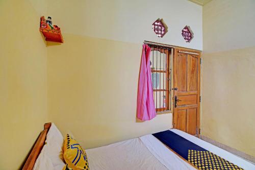 a bedroom with a bed and a window and a door at OYO Life 92954 Shanti Kost in Singaraja