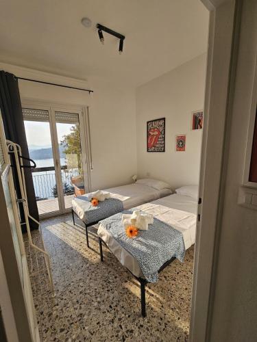 a bedroom with two beds and a balcony at Bella Vista da Mario, Lake Como, Front Lake Blevio in Blevio