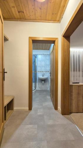 a hallway with a bathroom with a sink and a tub at Apartmán Kragujevská in Žilina