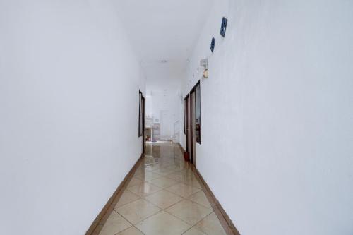 a hallway with white walls and a tile floor at OYO Life 93083 Nova Jaya 3 Homestay Syariah in Lamongan