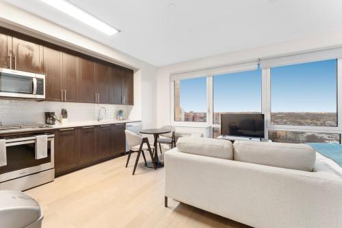 a living room with a couch and a kitchen with windows at Queens Studio Jewel Luxury and Comfort Combined in Mary Immaculate Hospital Heliport