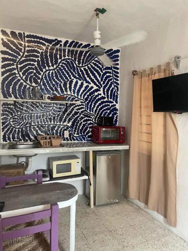 a room with a desk with a curtain and a table at Residencia Acosta #2 in Puerto Vallarta