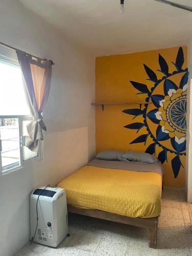 a bedroom with a bed with a flower on the wall at Residencia Acosta #2 in Puerto Vallarta
