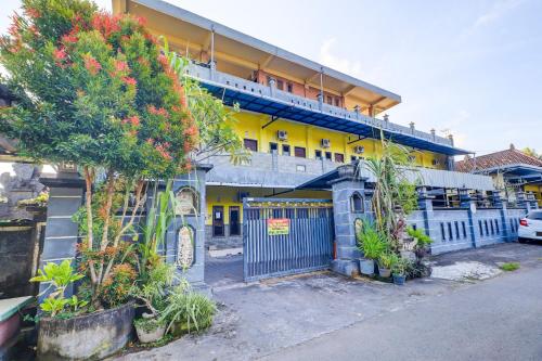 a building with a blue gate in front of it at OYO Life 92841 Kos 88 in Negara