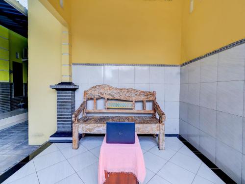 a bench in a room with a laptop on it at OYO Life 92841 Kos 88 in Negara