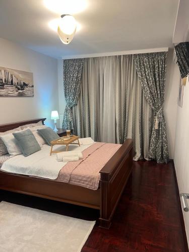a bedroom with a large bed and a window at Mona Lux apartman in Arandelovac