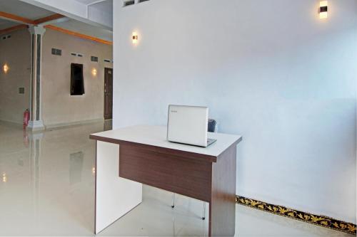 a laptop computer sitting on top of a desk at Hotel O Celine Home Syariah in Parit
