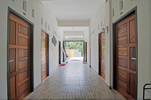 a hallway with wooden doors and a tile floor at Hotel O Celine Home Syariah in Parit