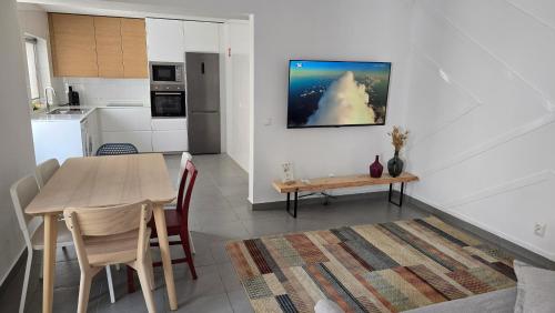 a kitchen and a dining room with a table and a kitchen at Santa Cruz Villas in Santa Cruz das Flores