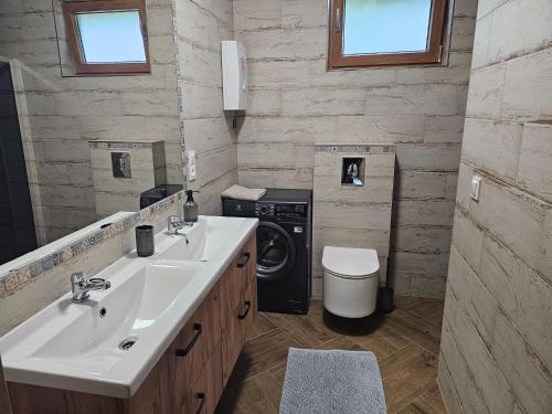 un bagno con lavandino e lavatrice di Holiday Home by Lake Wierzchowo with Private Beach a Grąbczyn