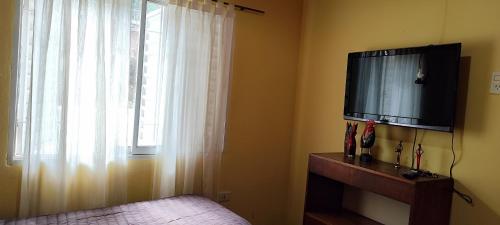 een slaapkamer met een televisie, een raam en een dressoir bij La Rufina chalet serrano in Río Ceballos