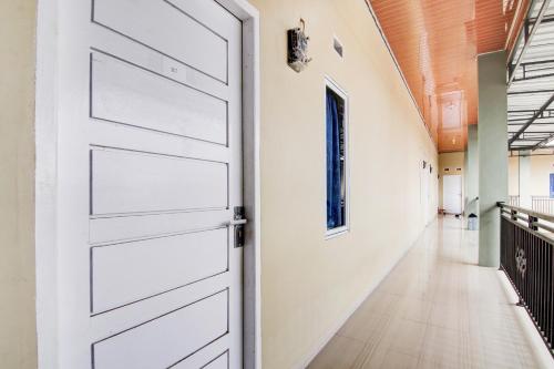 a white door in a hallway with a hallwaygue at OYO 93087 Wisma Apel Syariah in Parit