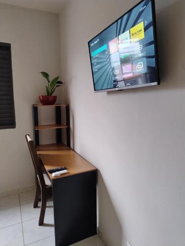 a room with a desk and a tv on the wall at quarto independente garagem moto in Sorocaba
