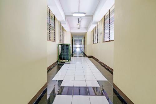 een gang van een gebouw met tegelvloeren en ramen bij OYO Life 92949 Apartemen Gateway Cicadas By Qq Rent in Bandung