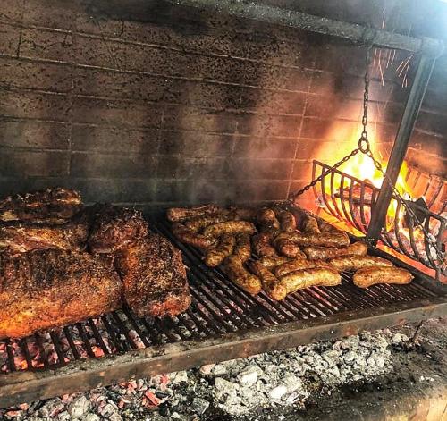 una parrilla con muchos tipos diferentes de carne. en Casa Quinta La Aves, en Estación La Plata