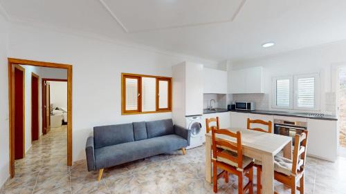 Una sala de estar con un sofá azul y una mesa. en Apartamento Relax 2, en Las Palmas de Gran Canaria