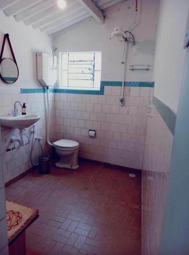 a bathroom with a toilet and a sink at Casa da Áfrika - Suíte Primavera in Itanhandu