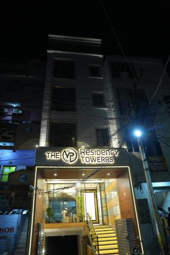 a building with a sign that says the hospitality towers at night at The VP Residency Towerrs in Tiruttani