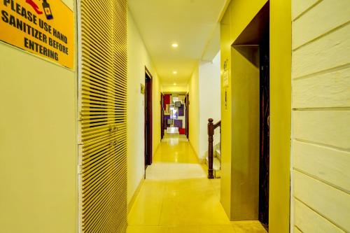a hallway with yellow walls and a long hallway at Hotel O Sunshin Deluxe in Nagpur