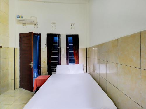 a bedroom with a large white bed in a room at OYO Life 92841 Kos 88 in Negara
